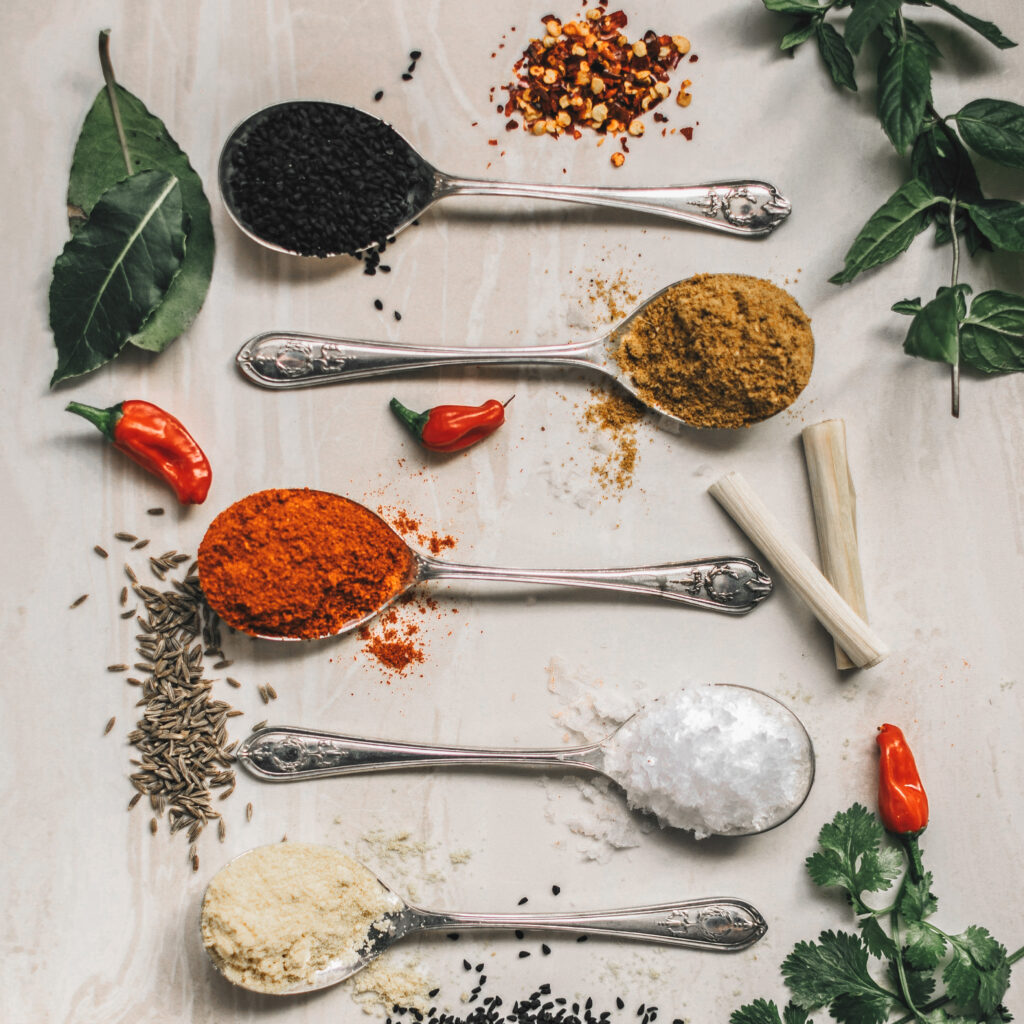 Colorful spices in spoon on table 